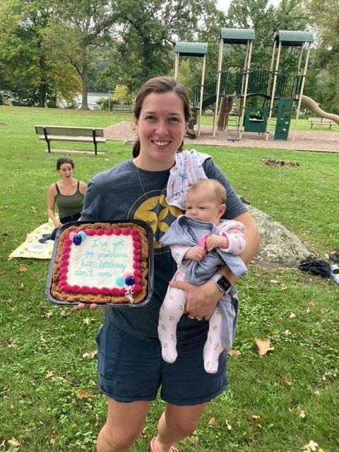 woman holding a cake and a baby